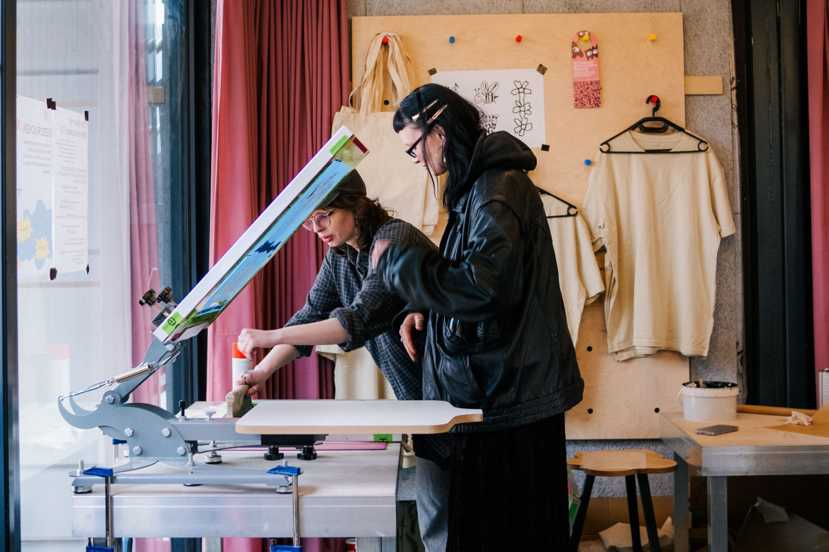 Zwei junge Frauen siebdrucken im Wanderspace