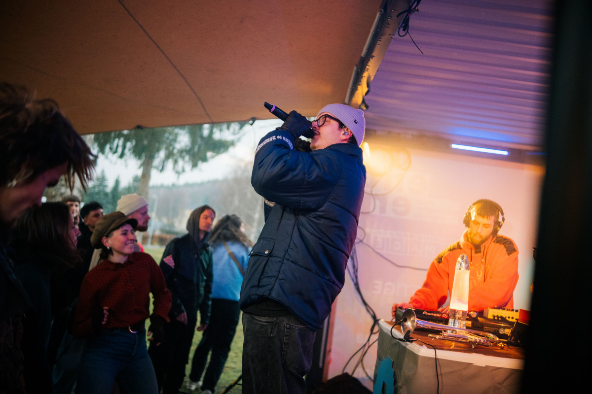 Musiker Nand singt auf der Bühne im Hintergrund spielt Lucidlavalamb