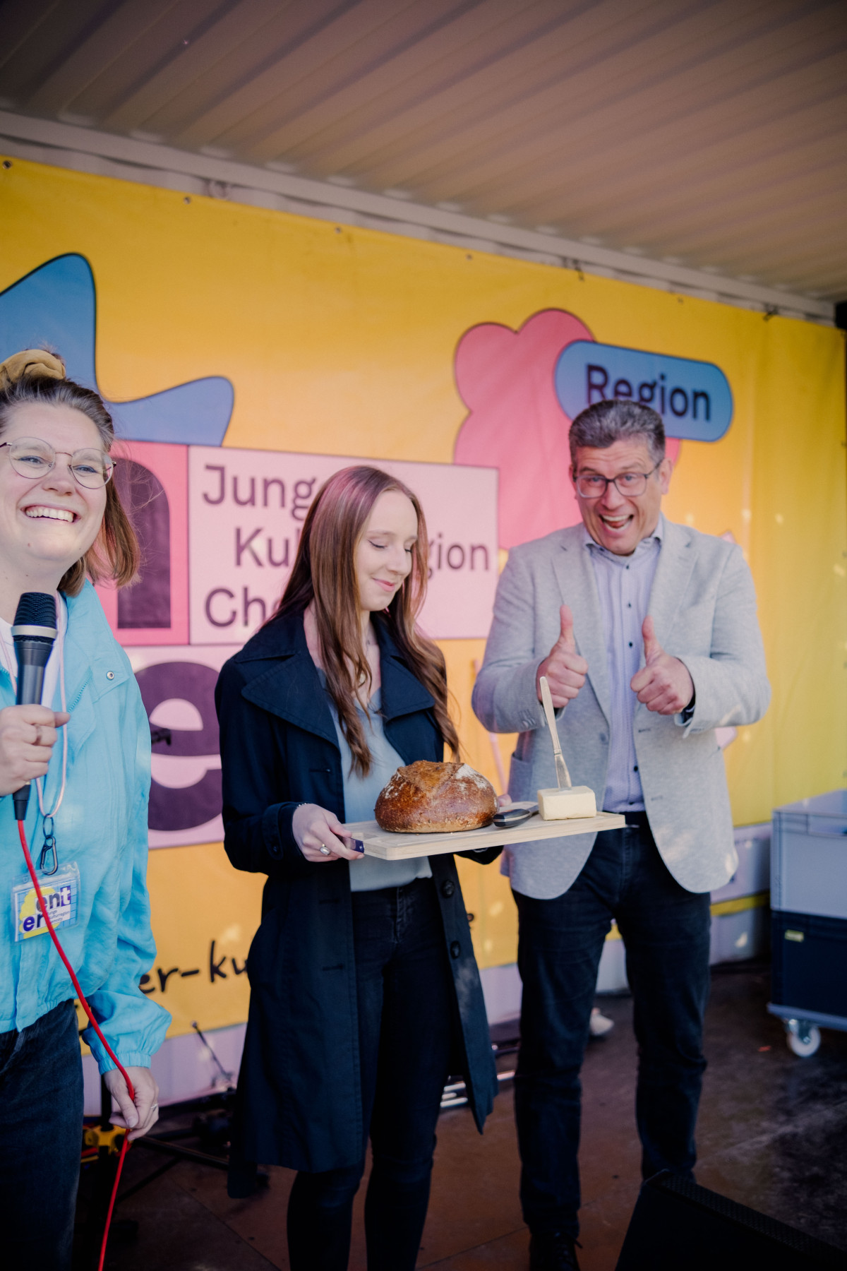Bürgermeister, Vorsitzende vom Jugenstadtrat und Jasmin auf der Bühne mit Brot und Salz
