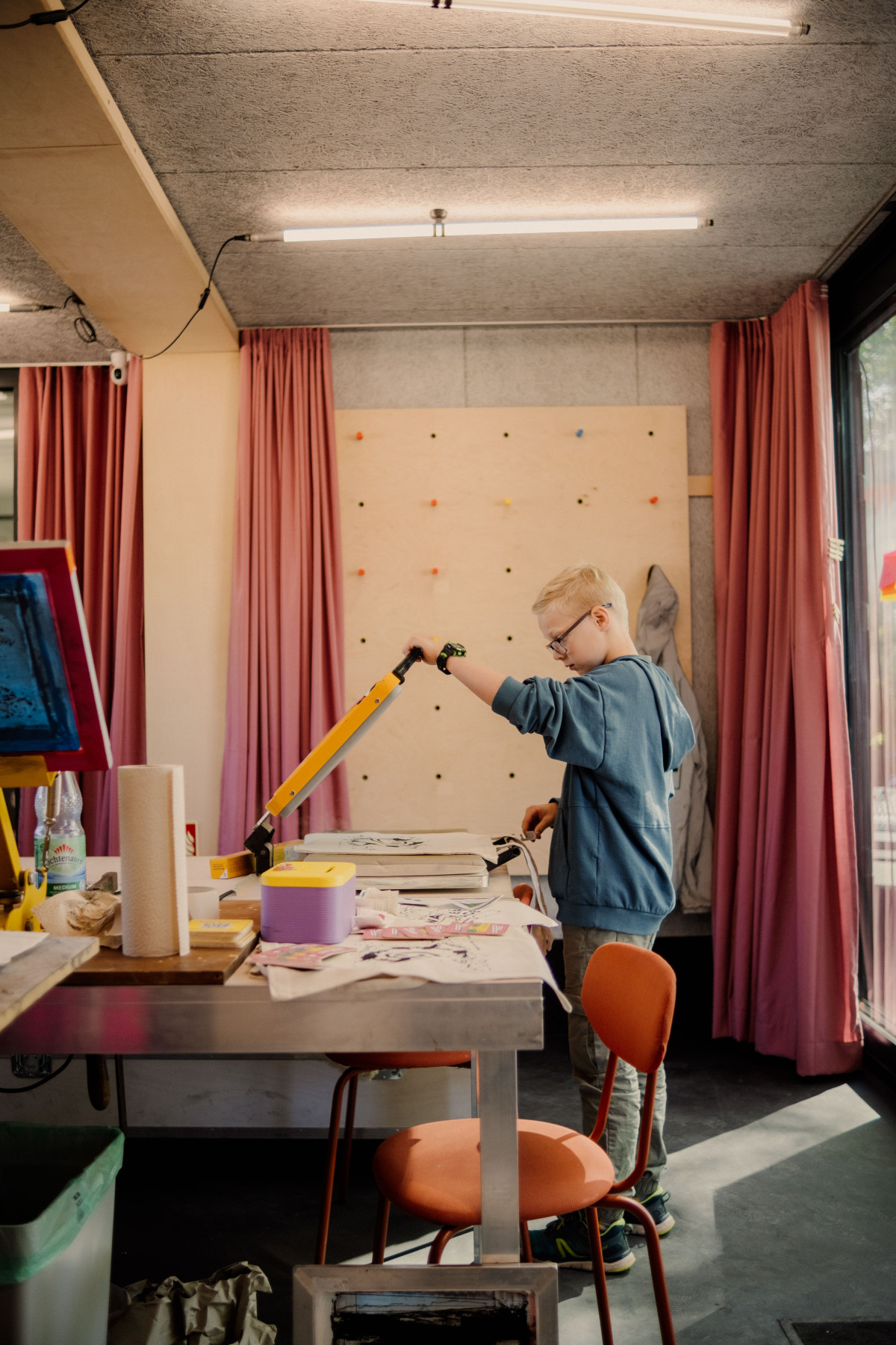 Kind an der Siebdruckpresse im Wanderspace