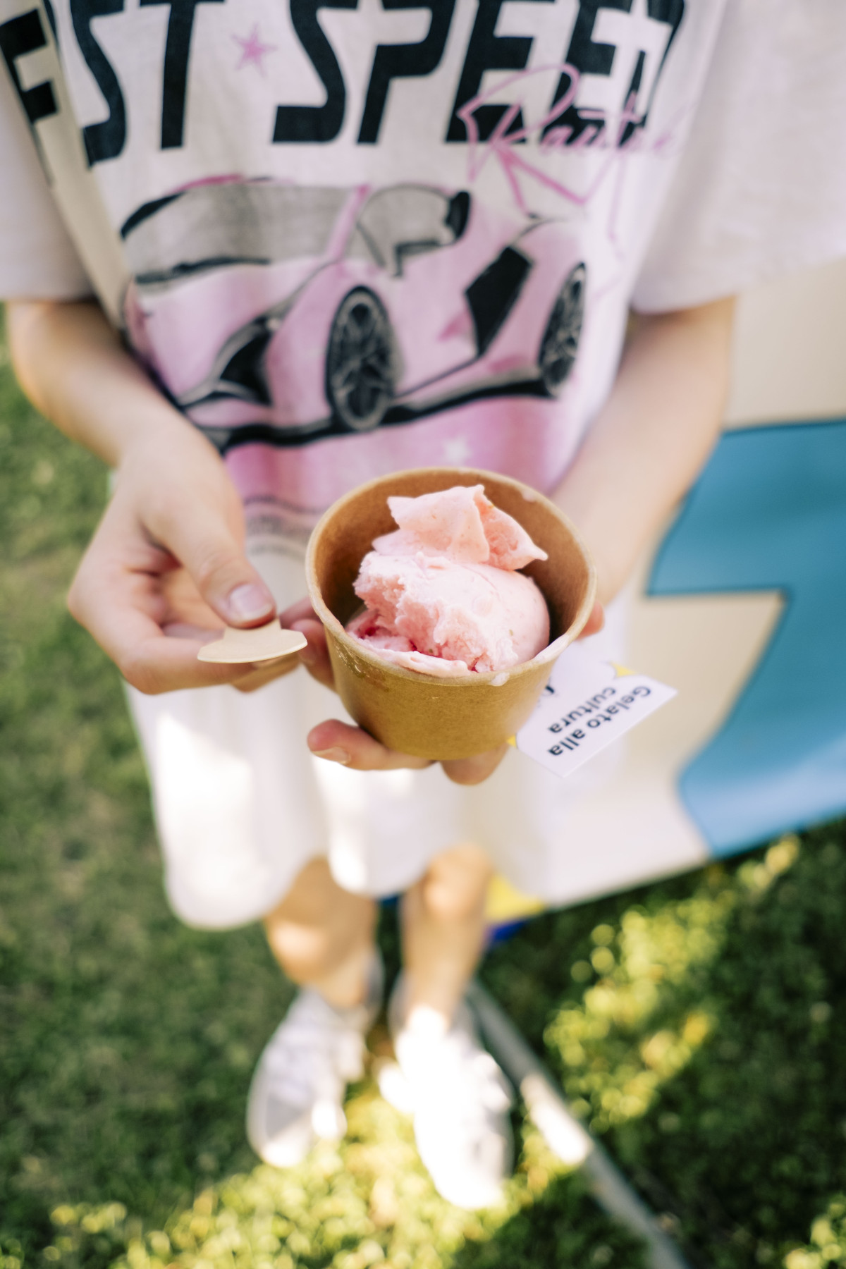 Person hält ein Eis im Becher