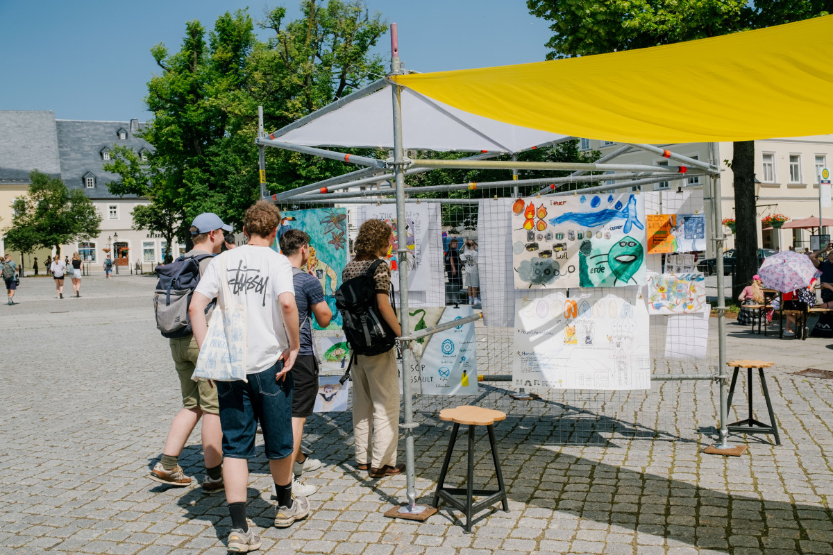 Menschen schauen sich eine Ausstellung auf dem Marktplatz an