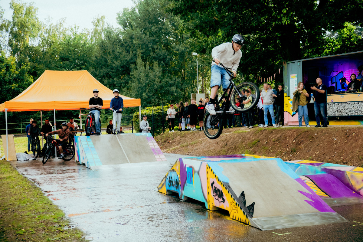Person springt mit BMX über Rampe