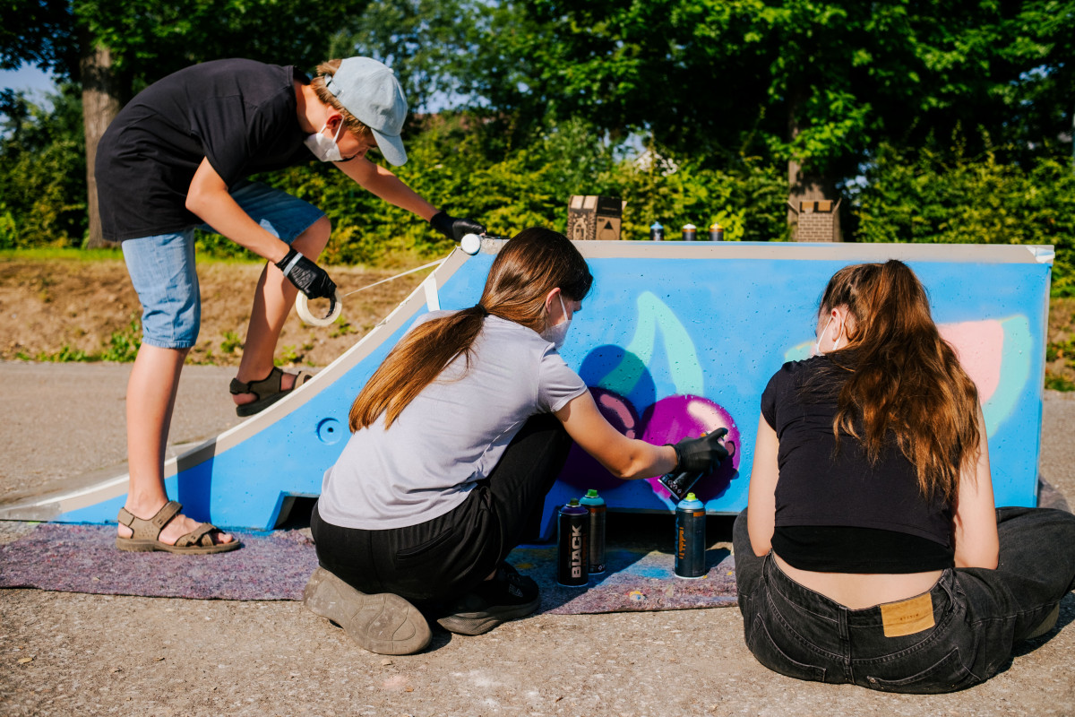 Drei Jugendliche sprühen auf ein Skate-Modul